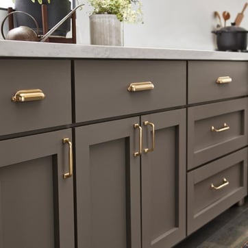 Brown shaker Kitchen cabinets with both gold cup pulls and decorative square pulls