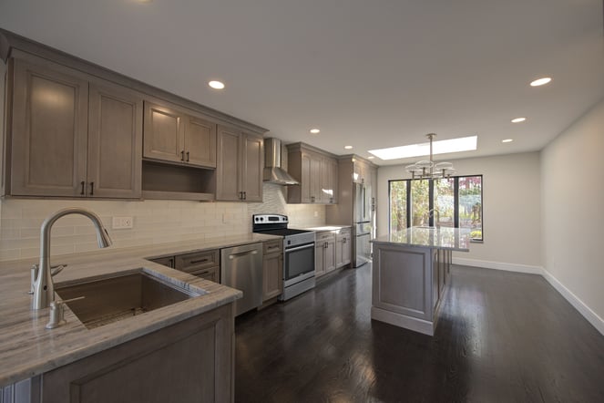 Contemporary kitchen with wood cabinetry and sleek countertops by Long Island Creative Contracting, Inc. in Northport, NY